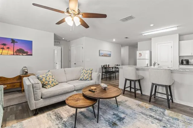 a living room with furniture kitchen view and a chandelier