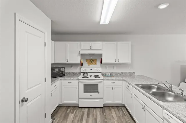 a kitchen with white cabinets stainless steel appliances and sink