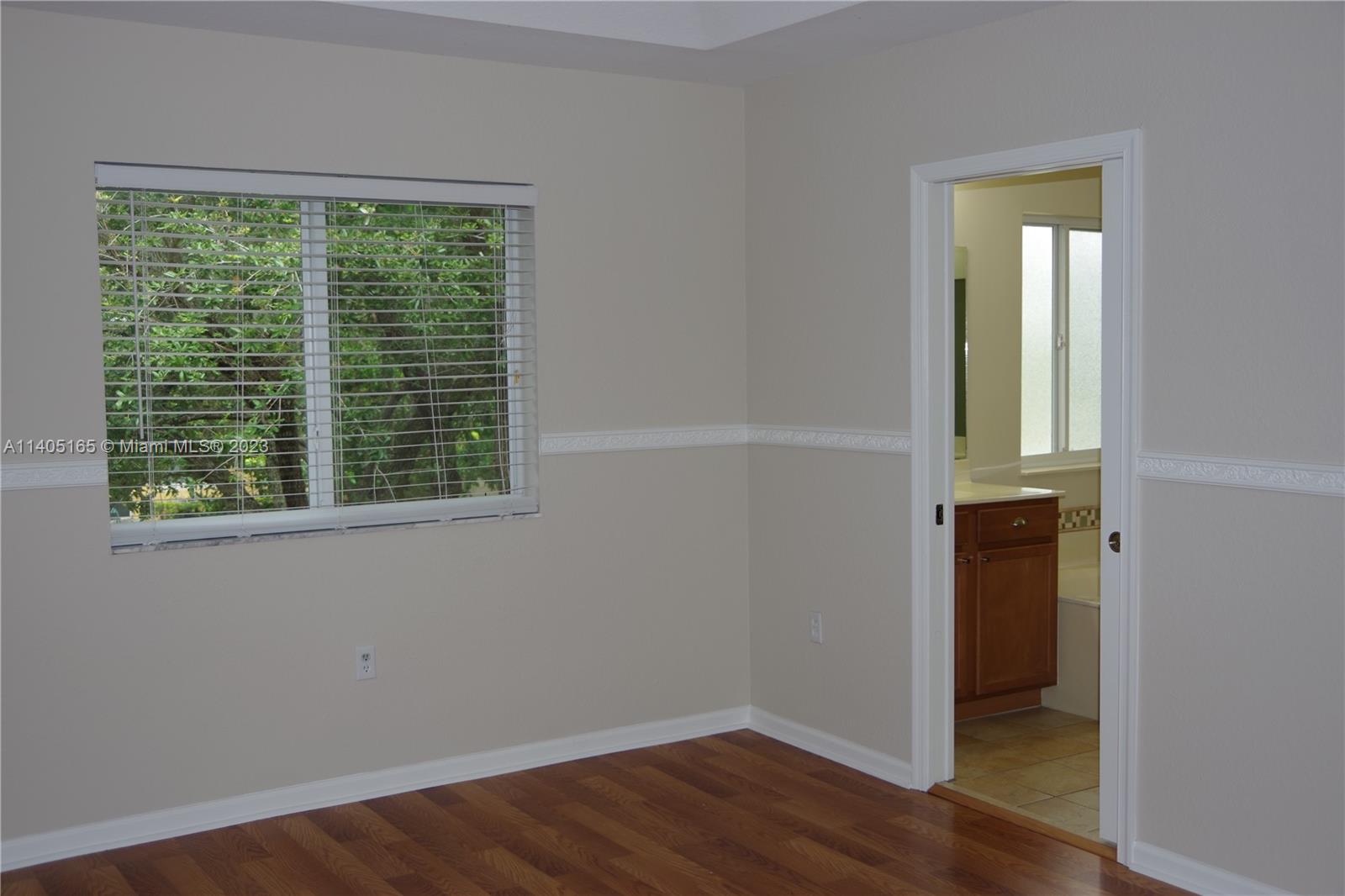 Walden Miami Gardens, FL 33169 - Photo 15 of 33 a view of an empty room with wooden floor and a window