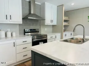 a kitchen with stainless steel appliances granite countertop a white stove top oven a sink and dishwasher