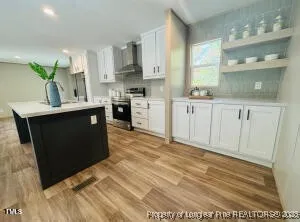 a kitchen with stainless steel appliances granite countertop a sink a stove and a refrigerator