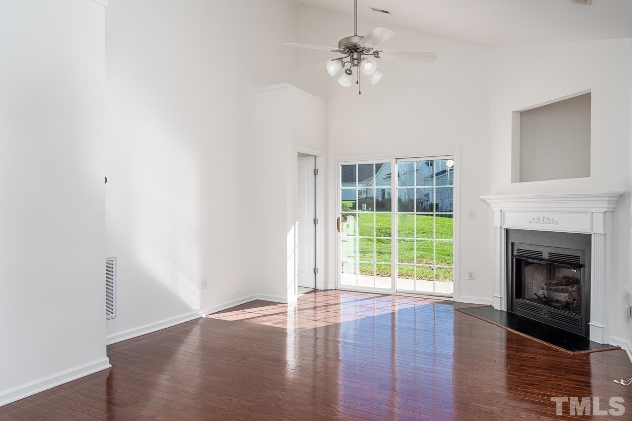 4 Cranbrook Court Durham, NC 27713 - Photo 6 of 30 a view of an empty room with wooden floor fireplace and a window