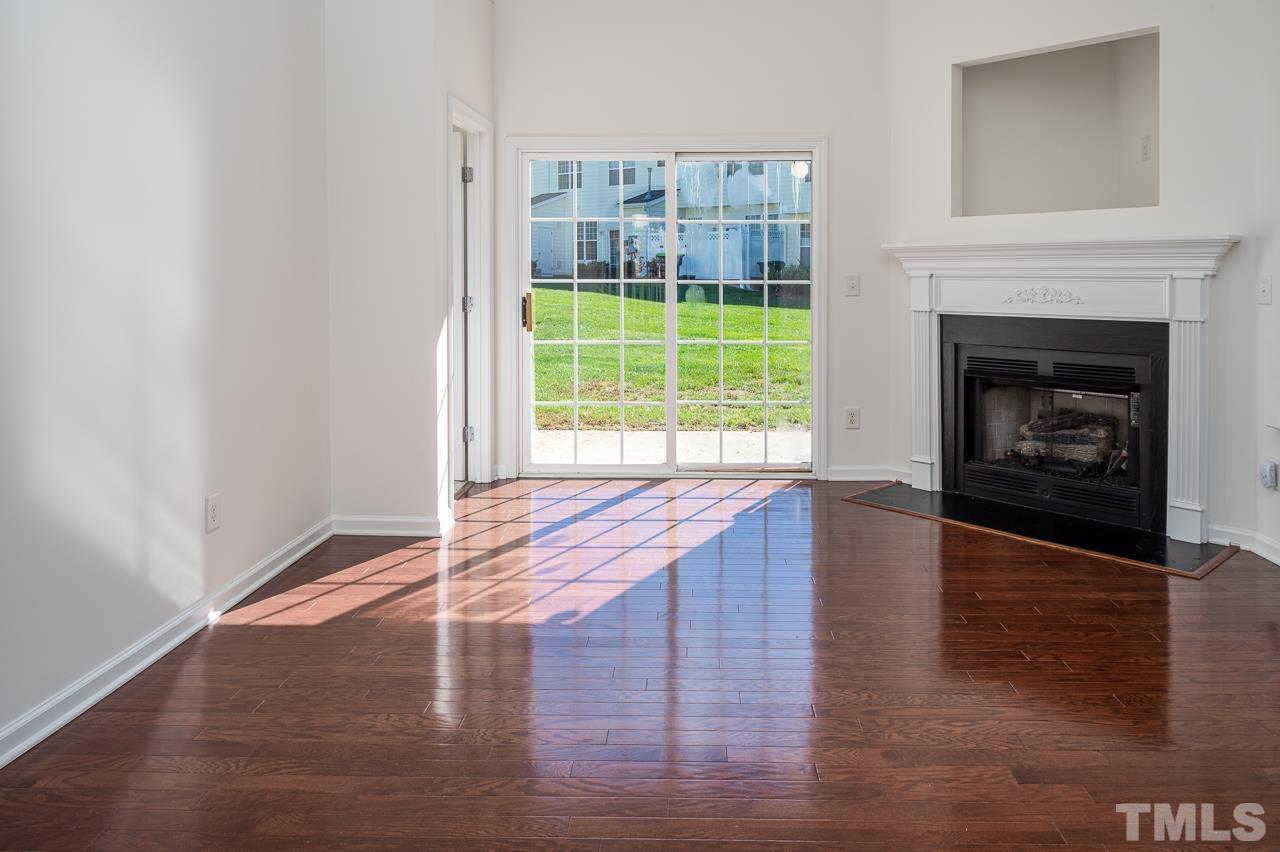 4 Cranbrook Court Durham, NC 27713 - Photo 8 of 30 a view of an empty room with wooden floor fireplace and a window
