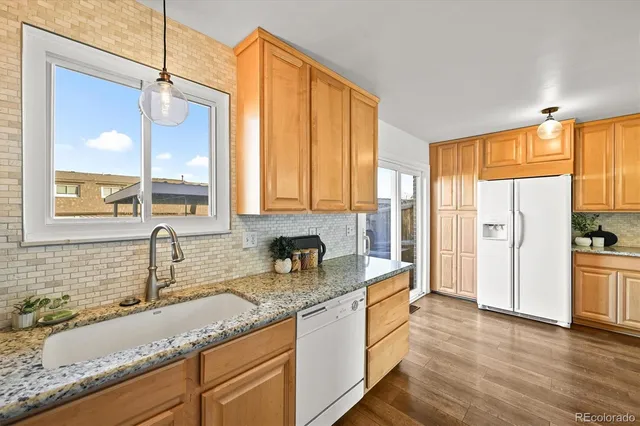 a bathroom with a granite countertop sink and a window