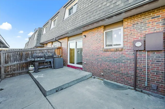 a backyard of a house with barbeque oven and outdoor seating