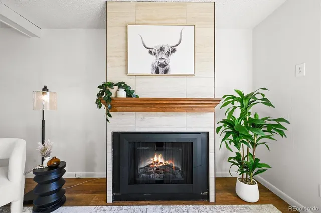 a living room with a fireplace and potted plant