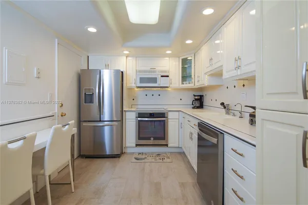 a kitchen with a refrigerator sink and cabinets