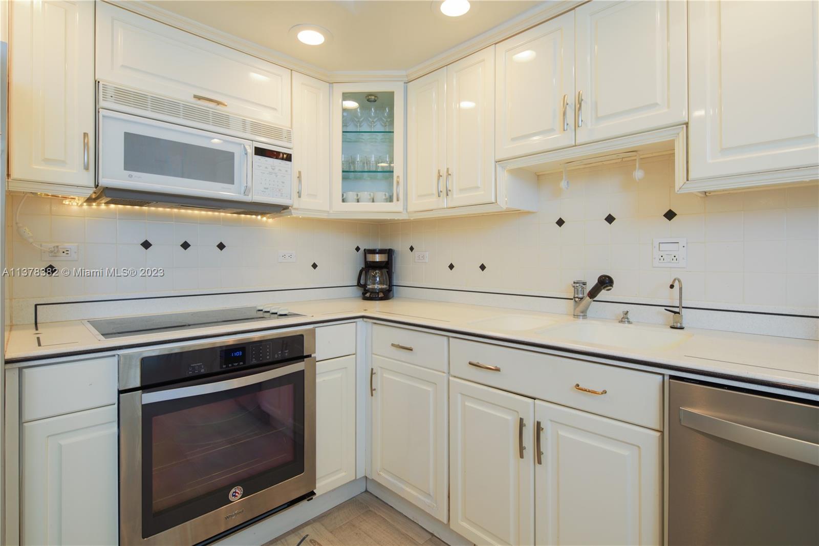 5005 Collins Avenue, Unit 610 Miami Beach, FL 33140 - Photo 12 of 31 a kitchen with cabinets appliances and a sink