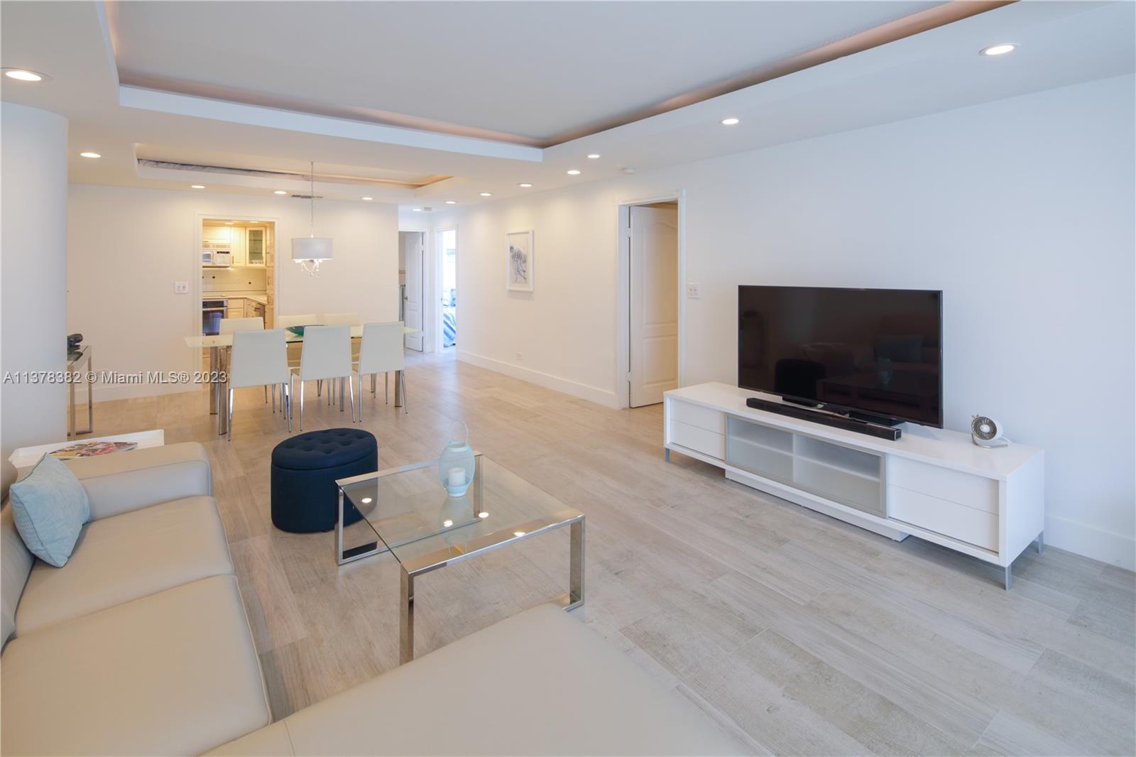5005 Collins Avenue, Unit 610 Miami Beach, FL 33140 - Photo 7 of 31 a living room with furniture and a flat screen tv