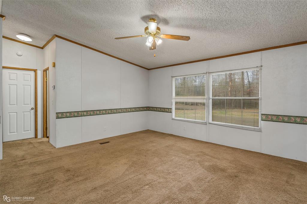 1230 Chipper Lane Keithville, LA 71047 - Photo 13 of 27 an empty room with windows and ceiling fan