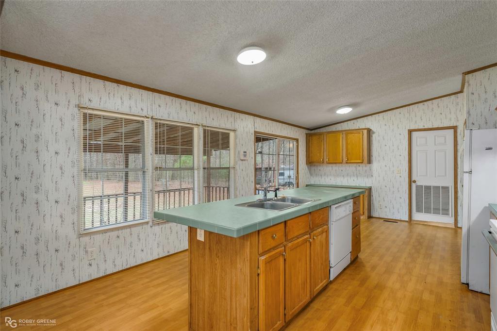 1230 Chipper Lane Keithville, LA 71047 - Photo 15 of 27 a kitchen with kitchen island a sink windows and a dining table