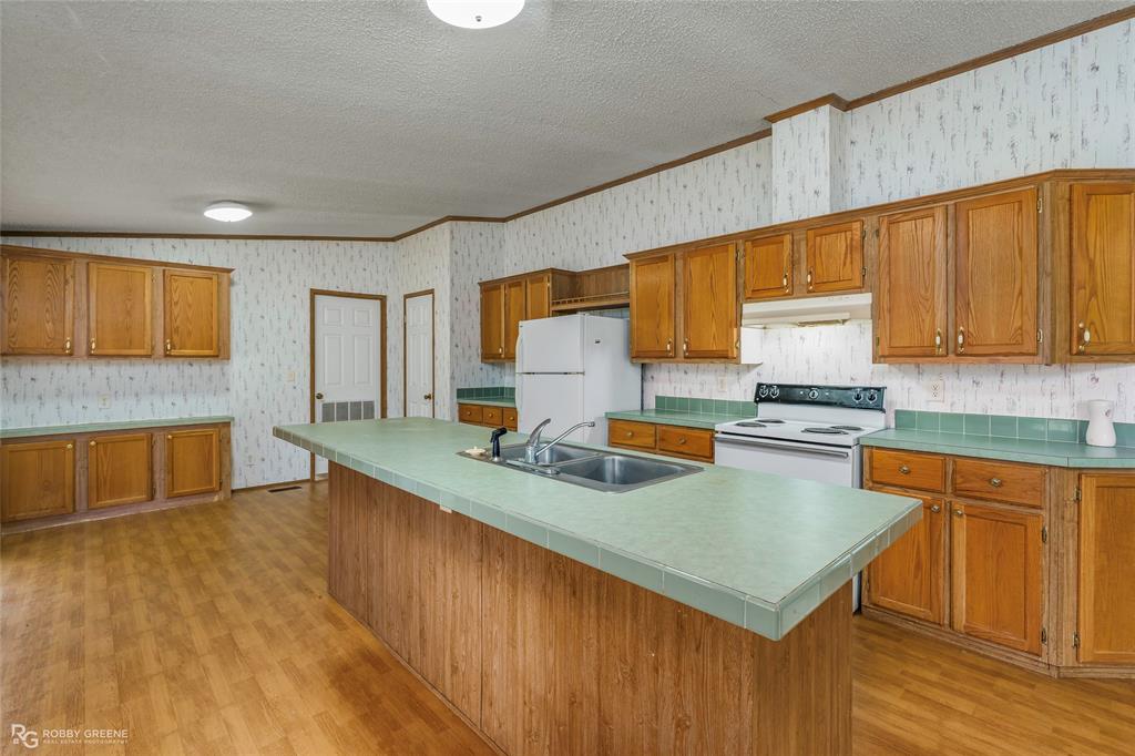 1230 Chipper Lane Keithville, LA 71047 - Photo 16 of 27 a kitchen with stainless steel appliances a sink a stove top oven a counter space and cabinets