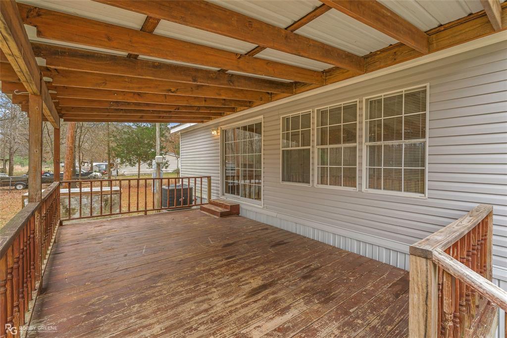 1230 Chipper Lane Keithville, LA 71047 - Photo 3 of 27 a view of a porch with wooden floor and roof with a garden view