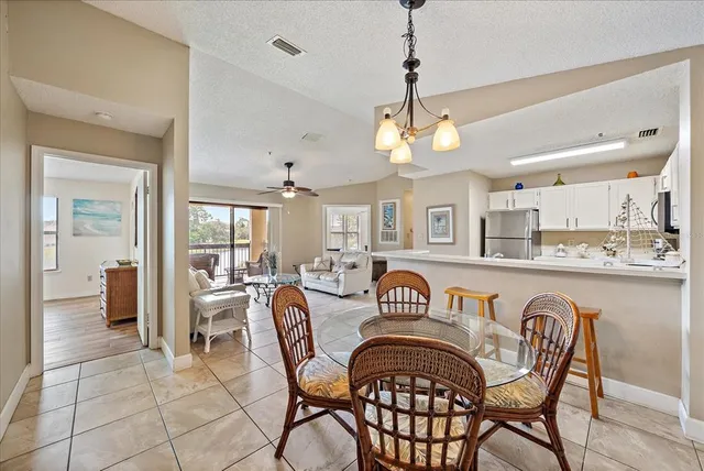 a view of a dining room and livingroom with furniture wooden floor a chandelier