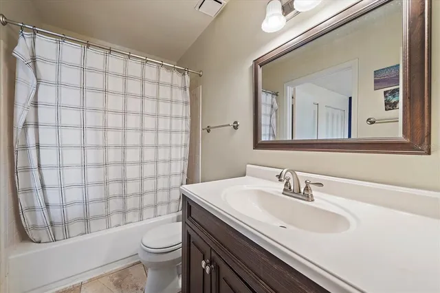 a bathroom with a sink a toilet and shower curtain