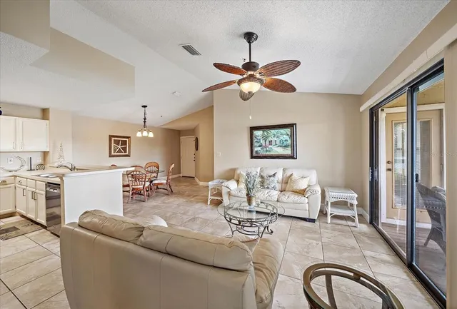 a living room with furniture a ceiling fan and a window