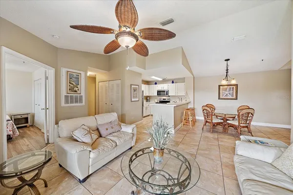 a living room with furniture kitchen view and a chandelier