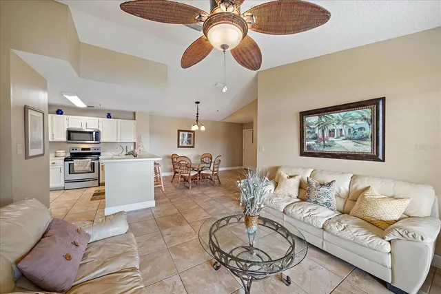 a living room with furniture kitchen view and a chandelier