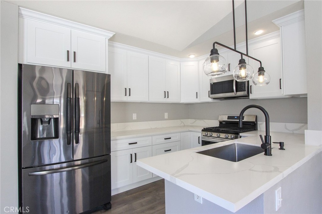 12640 Briarglen Loop, Unit F Stanton, CA 90680 - Photo 1 of 25 a kitchen with stainless steel appliances a refrigerator sink and microwave
