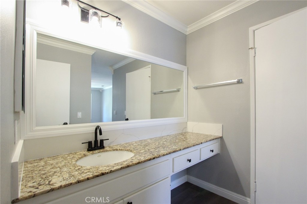12640 Briarglen Loop, Unit F Stanton, CA 90680 - Photo 13 of 25 a bathroom with a granite countertop sink and a mirror