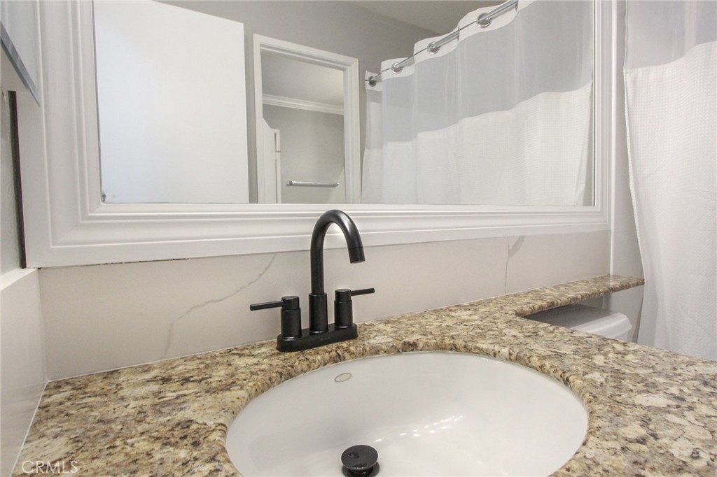 12640 Briarglen Loop, Unit F Stanton, CA 90680 - Photo 20 of 25 a bathroom with a granite countertop sink and vanity
