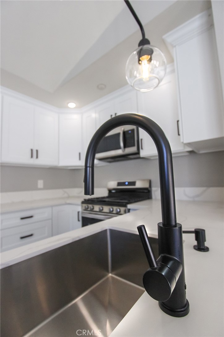 12640 Briarglen Loop, Unit F Stanton, CA 90680 - Photo 3 of 25 a kitchen with a sink and cabinets