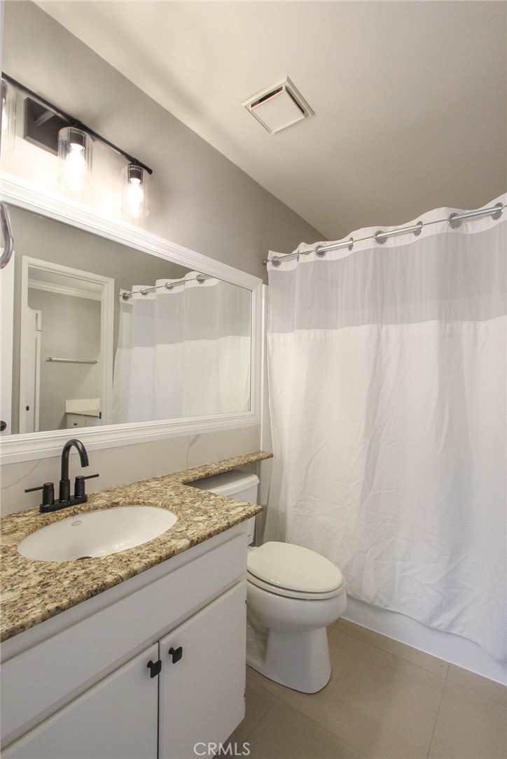 12640 Briarglen Loop, Unit F Stanton, CA 90680 - Photo 9 of 25 a bathroom with a granite countertop sink toilet and shower