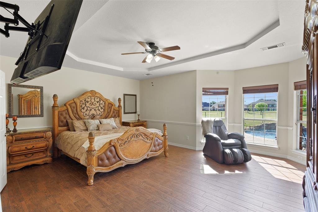 10414 Broadmoor Lane Rowlett, TX 75089 - Photo 15 of 38 Bedroom with a tray ceiling, wood finished floors, and a ceiling fan