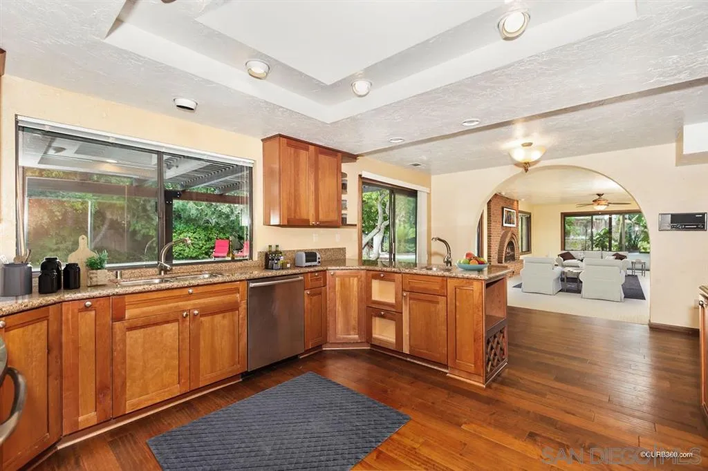 1156 Wild Canary Lane Encinitas, CA 92024 - Photo 8 of 20 a large kitchen with stainless steel appliances granite countertop a lot of counter space and a wooden floors