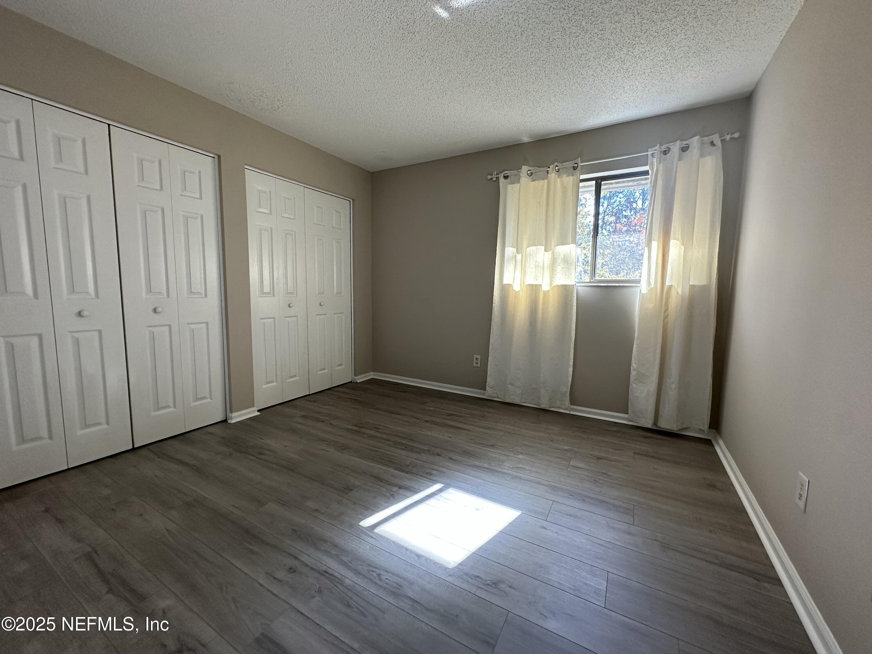 3801 Crown Point Road, Unit 3082 Jacksonville, FL 32257 - Photo 23 of 41 an empty room with wooden floor and windows