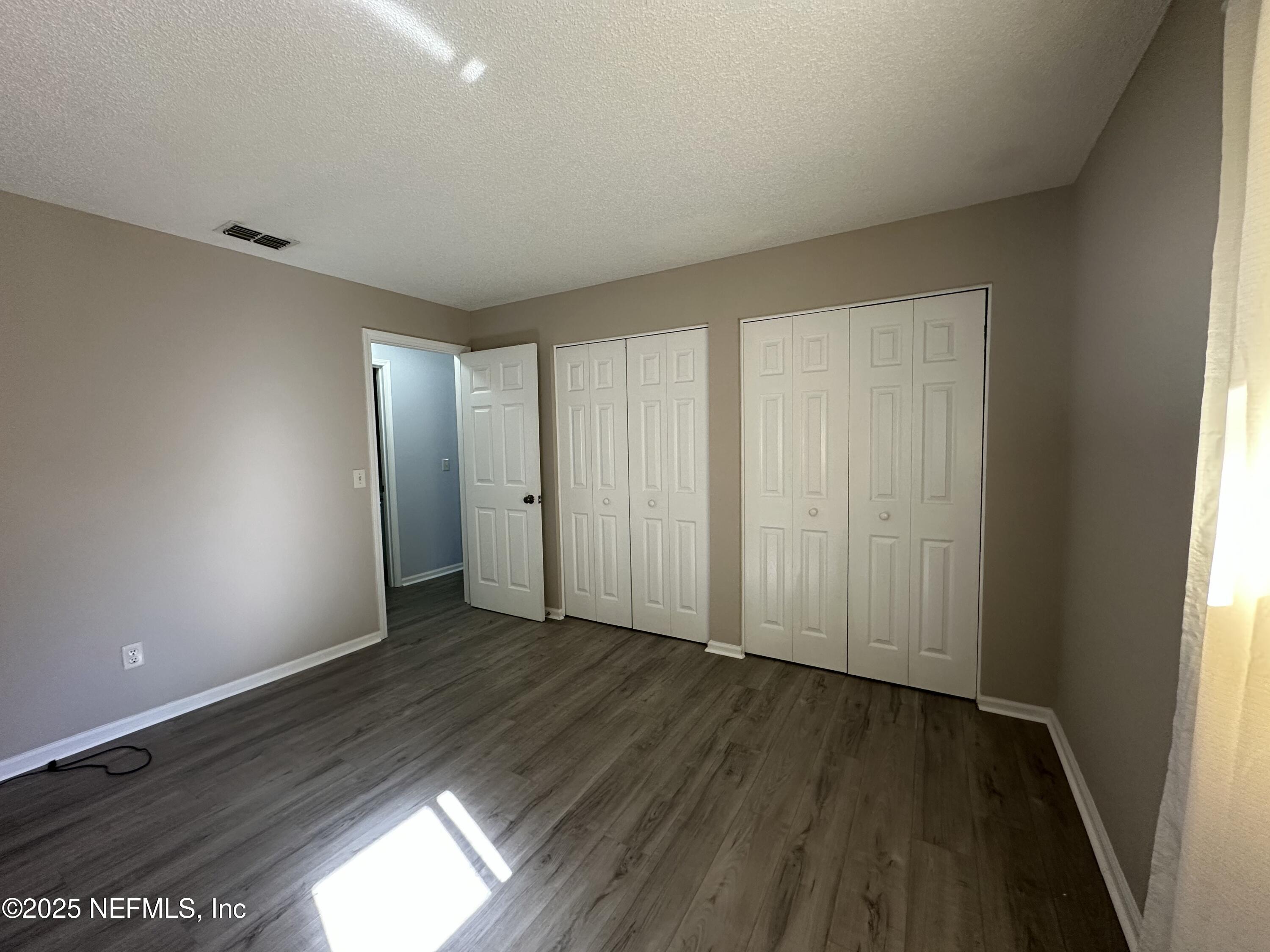 3801 Crown Point Road, Unit 3082 Jacksonville, FL 32257 - Photo 24 of 41 an empty room with wooden floor and windows
