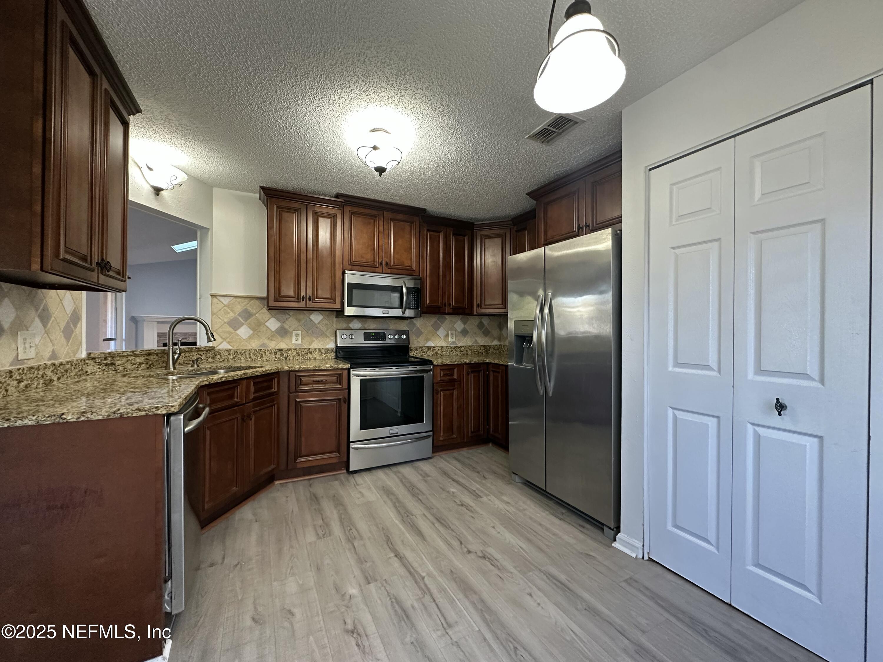 3801 Crown Point Road, Unit 3082 Jacksonville, FL 32257 - Photo 8 of 41 a kitchen with stainless steel appliances granite countertop a refrigerator a sink dishwasher a stove and a microwave oven on granite countertops