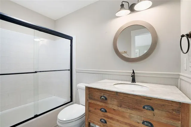 a bathroom with a granite countertop sink toilet and a mirror