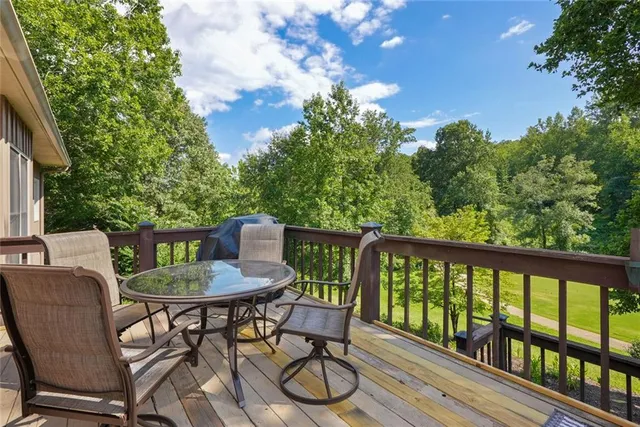 a balcony with wooden floor table and chairs
