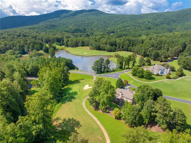 an aerial view of a house with a yard and lake view
