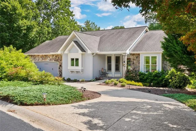 a front view of a house with a yard and potted plants