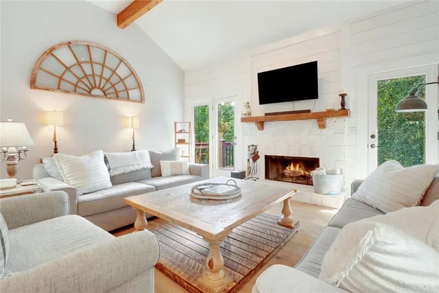 a living room with furniture a fireplace and a flat screen tv