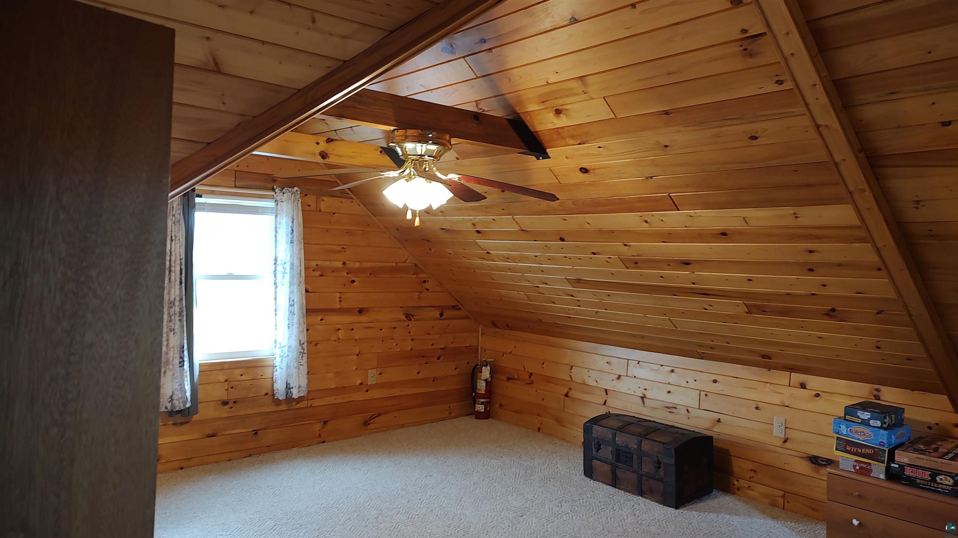 2585 Hautala Road Iron River, WI 54847 - Photo 15 of 28 Vaulted wood-paneled ceiling with exposed wood beam and ceiling fan light fixture