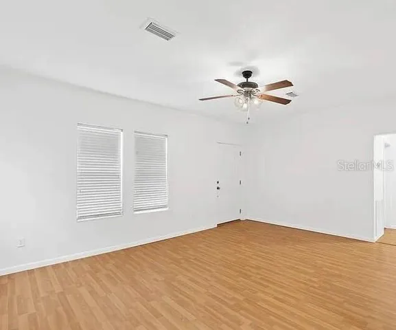 wooden floor in an empty room with a window