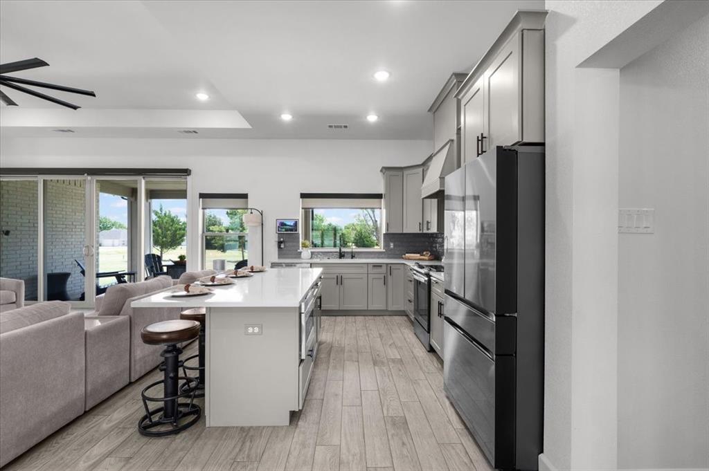 1039 Monaco Court Springtown, TX 76082 - Photo 7 of 33 Contemporary kitchen featuring gray cabinetry, stainless steel appliances, and plenty of natural light