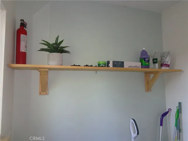 a white painted room with wooden floor and cabinets
