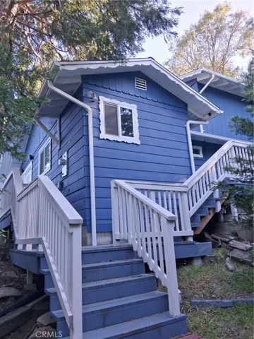 a view of a house with wooden deck and a yard