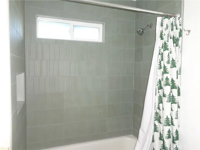 a bathroom with a shower curtain and window