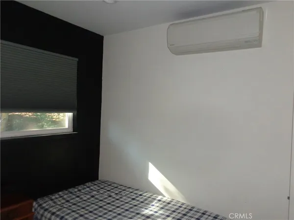 a bed sitting in a spacious bedroom next to a bathroom