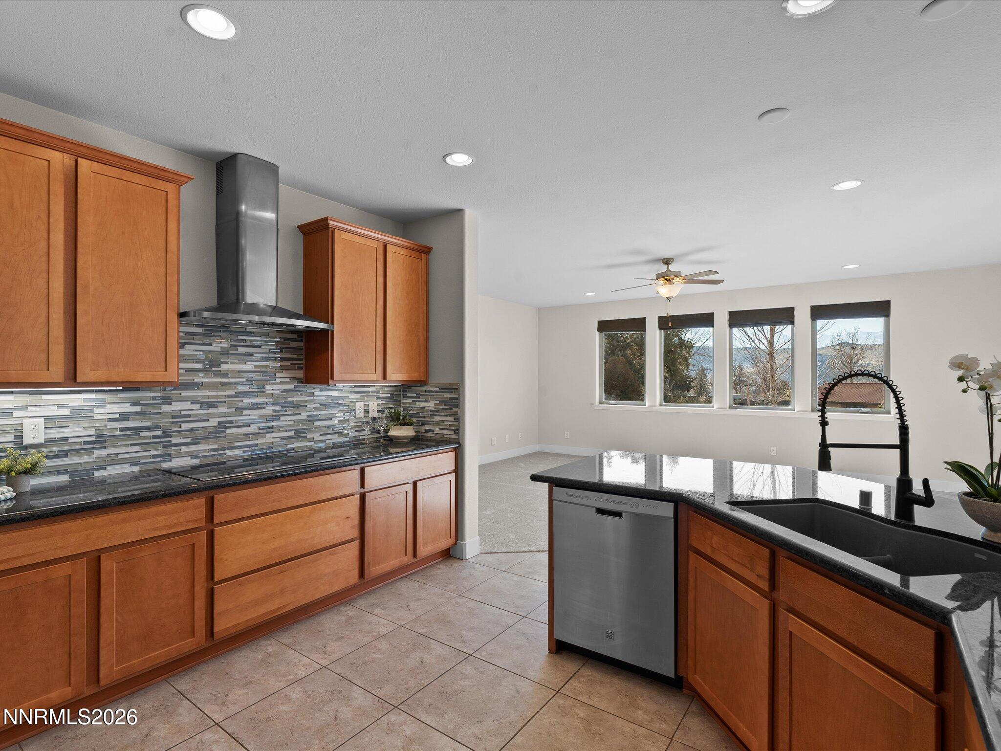5585 East Hidden Valley Drive Reno, NV 89502 - Photo 13 of 40 a kitchen with stainless steel appliances granite countertop a stove a sink and a microwave