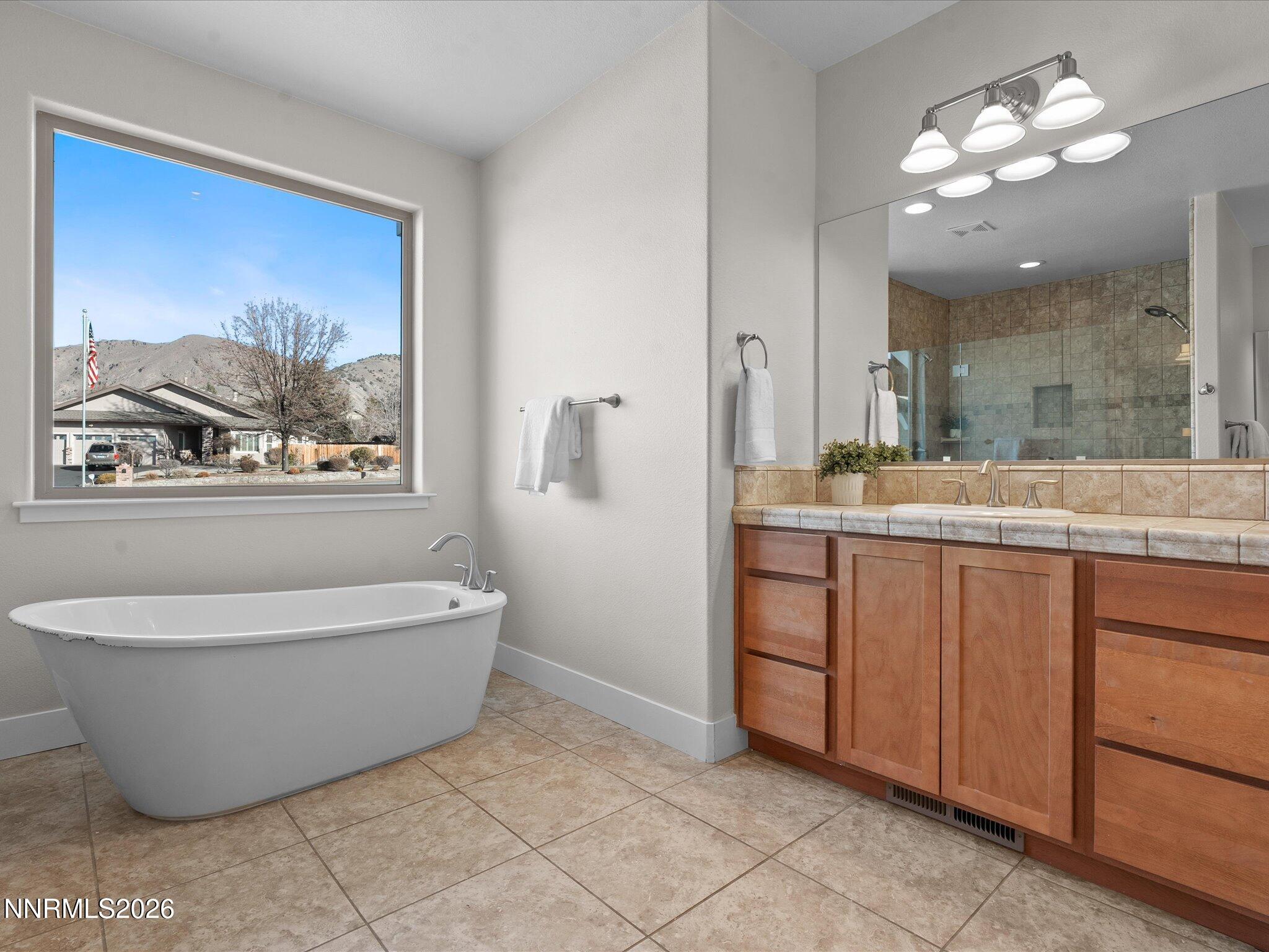 5585 East Hidden Valley Drive Reno, NV 89502 - Photo 21 of 40 a spacious bathroom with a double vanity sink a mirror and a bathtub