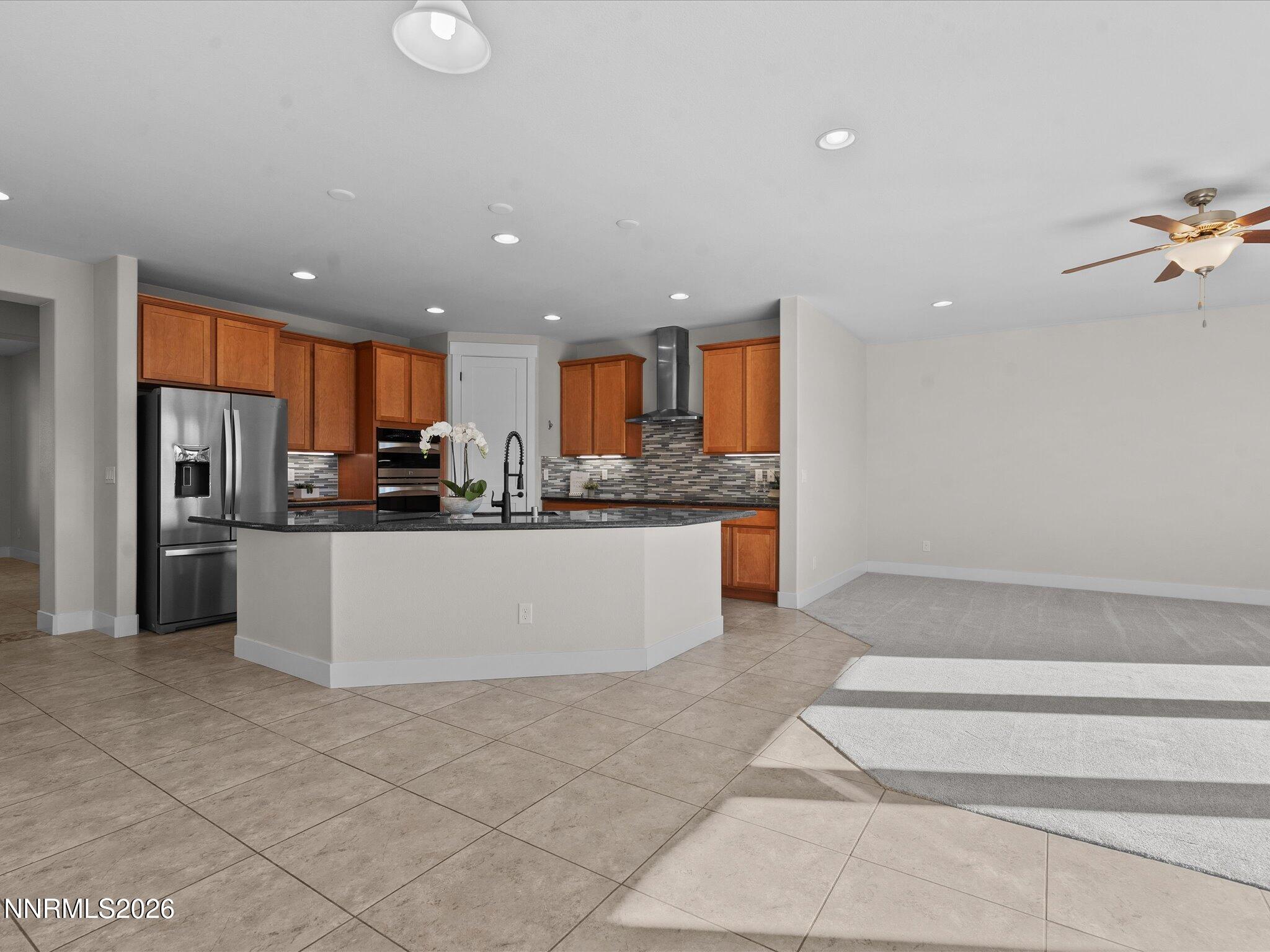 5585 East Hidden Valley Drive Reno, NV 89502 - Photo 7 of 40 a large kitchen with stainless steel appliances kitchen island granite countertop a refrigerator and a stove top oven