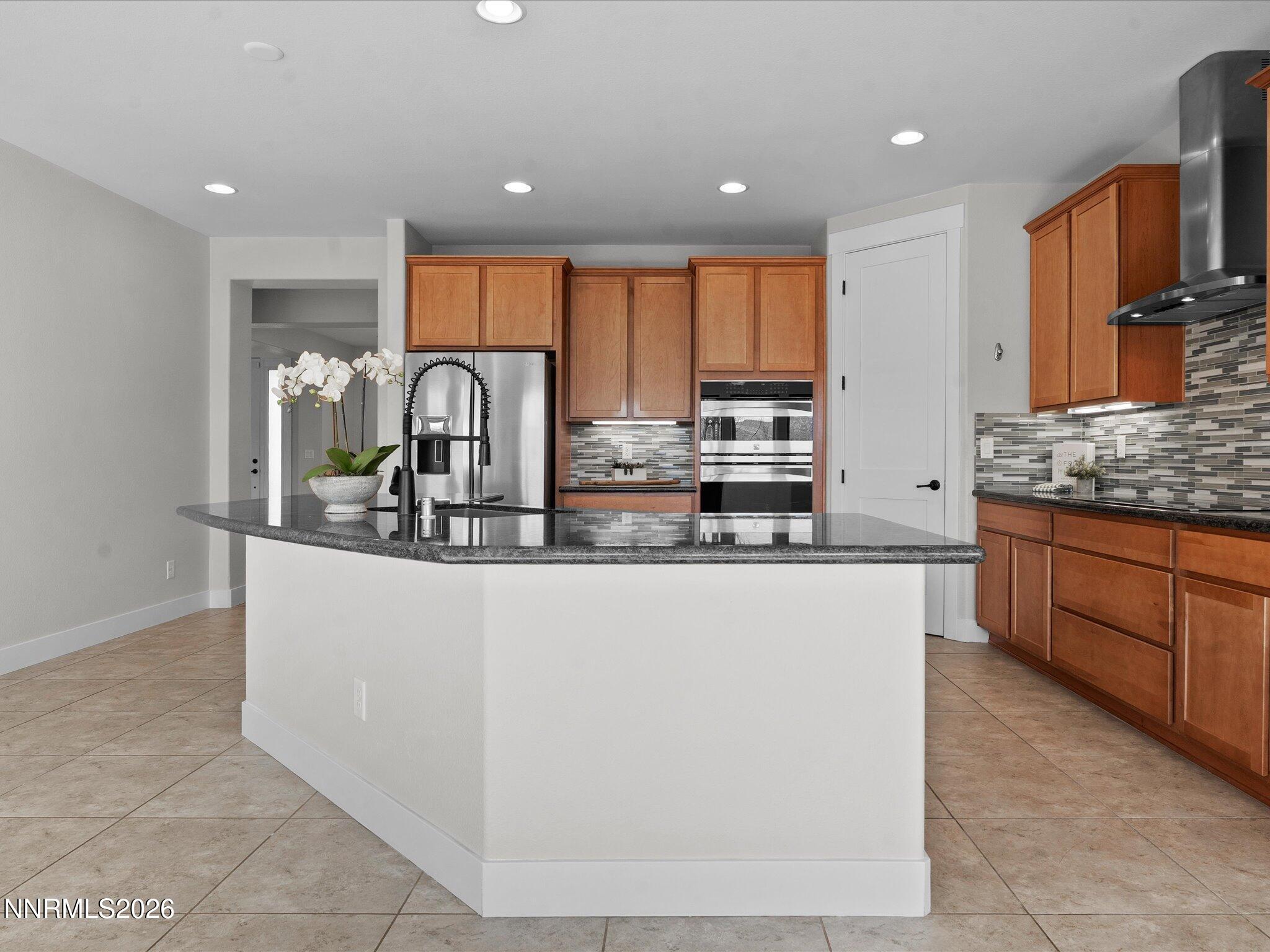 5585 East Hidden Valley Drive Reno, NV 89502 - Photo 9 of 40 a kitchen with stainless steel appliances granite countertop a stove a sink and a microwave