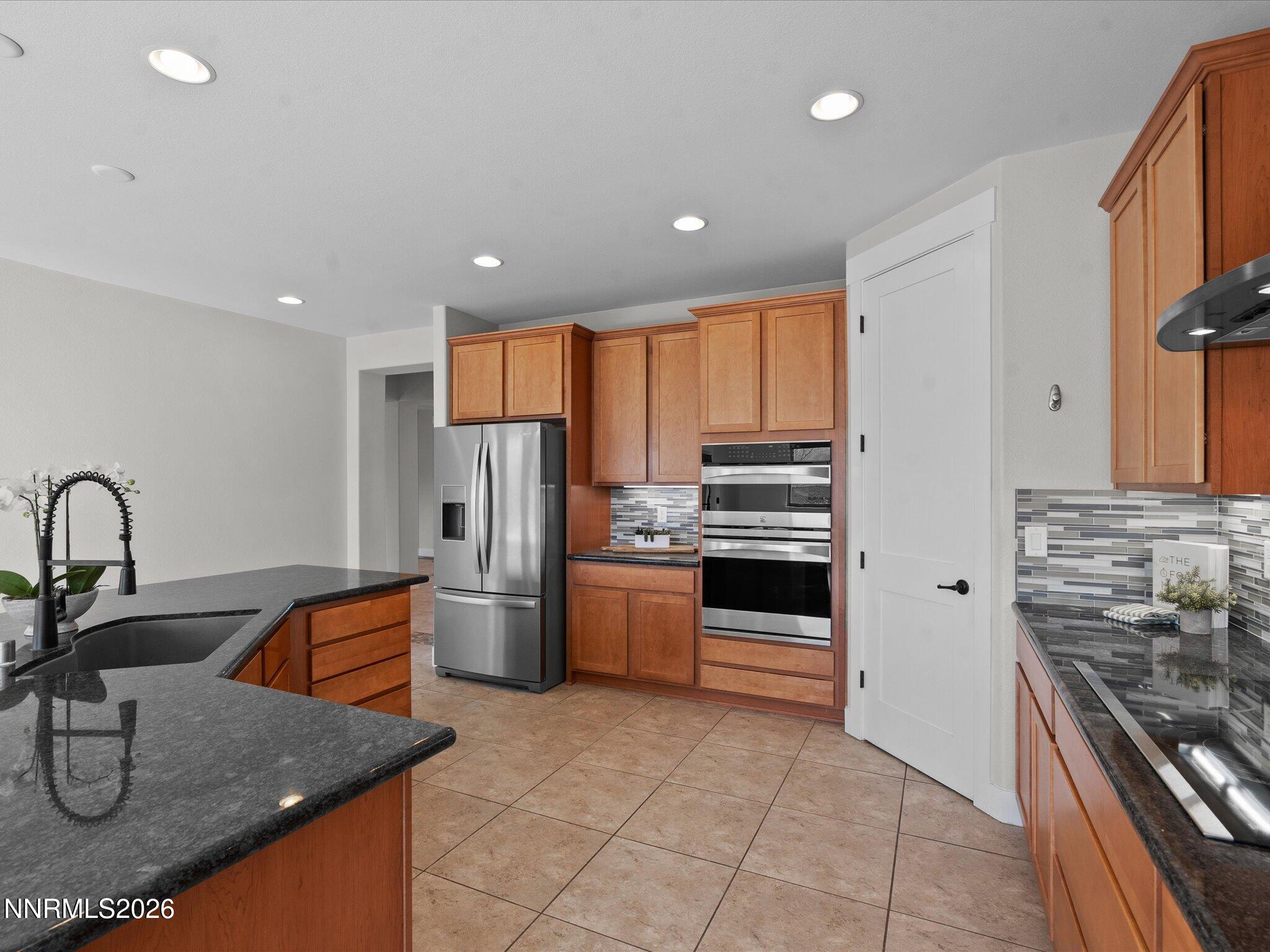 5585 East Hidden Valley Drive Reno, NV 89502 - Photo 10 of 40 a kitchen with stainless steel appliances granite countertop a sink stove and refrigerator