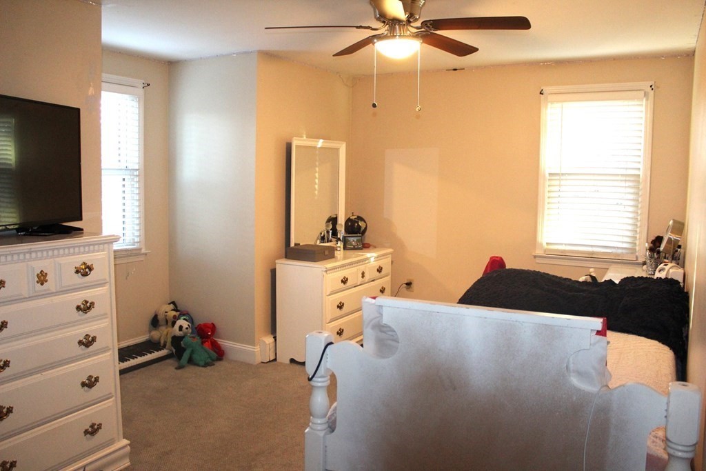 25 3rd Avenue Bellingham, MA 02019 - Photo 10 of 20 a bed room with a bed and a flat tv screen on a dresser